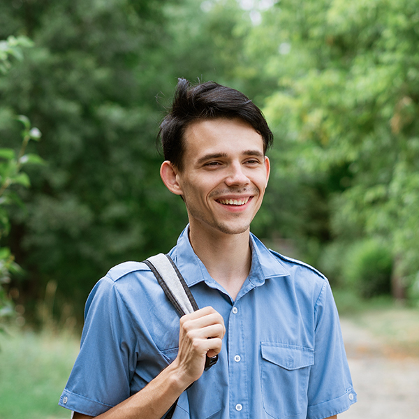 ID Forest - young cheerful guy student stands in a blue shirt lcug2rr
